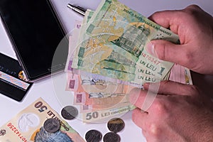 Man holding Romanian lei banknotes, close-up on white background