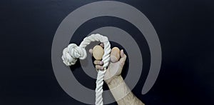 Man holding rope and two eggs showing erectile dysfunction