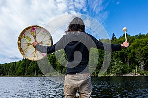 Man holding sacred drum and fur covered stick