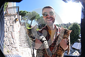 Man holding Savannah cat and Bengal cat