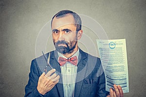 Man holding scissors and contract in his hands, ready to cut it