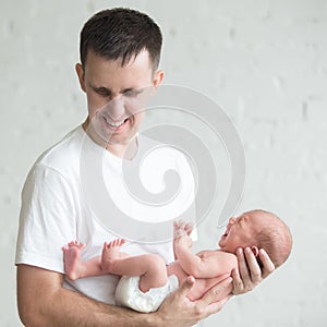 Man holding a screaming newborn