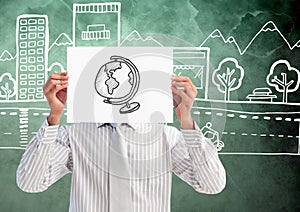 Man holding sheet of paper with drawn globe in front of his face and graphics in background