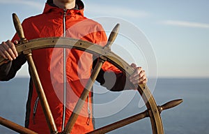 Man holding ship rudder with sea on background