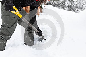 Man holding shovel while shoveling snow.