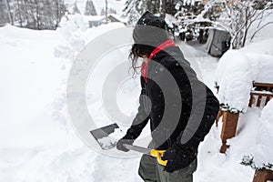 Man holding shovel while shoveling snow.