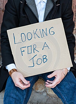 Man holding a sign saying I am looking for a job