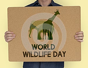 Man holding a sign with World Wildlife Day