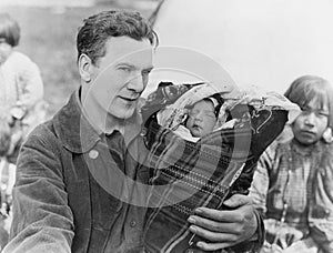 Man holding sleeping baby in papoose