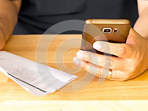 A man holding smart phone for using online banking app for paying credit card bill