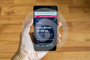 Man holding smartphone with Cambridge Analytica web