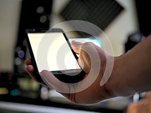 Man holding smartphone / cell phone in hand with blank screen.