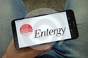 Man holding smartphone with Entergy Corporation logo