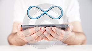 Man holding smartphone with a Infinity symbol