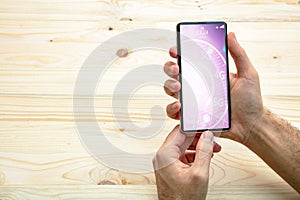 Man holding a smartphone, internet speed test on the screen, wooden background, copy space