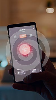 Man holding smartphone with lighting control application, turning on bulbs