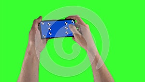 Man is holding smartphone by two hands and swiping up on display with tracking points on greenscreen