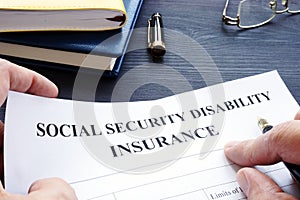 Man holding Social Security Disability Insurance SSDI policy.