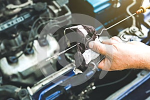 Man holding spark plug in old car engine. Oil level in the tank. Inner details of machine. Repairing of vehicle