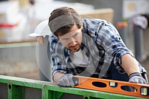 man holding spirit level at construction site