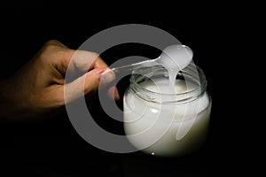 Man holding a spoon over a jar of mastic gum