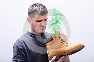 Man Holding Stinky Shoes