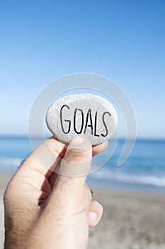 Man holding a stone with the text goals