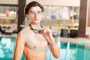 Man holding swimming googles and looking