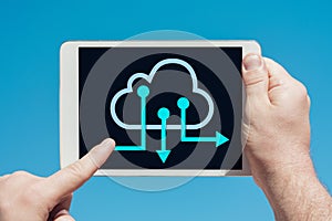 Man holding a tablet device and cloud computing communication icon to download stored data