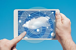 Man holding a tablet device and cloud computing communication icon to download stored data
