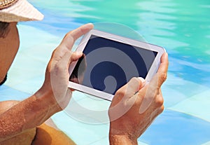 Man holding tablet poolside