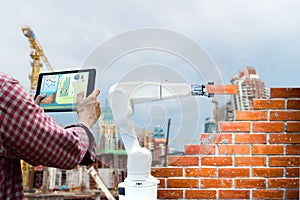 Man holding a tablet Remote control Smart robot industry 4. 0 arm brick building construction human force