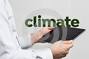 Man holding a tablet with the word climate in the background