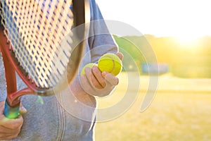 Man holding tenis racket and ball at court on sunny day photo