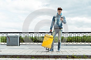 Man holding thermo bag and using