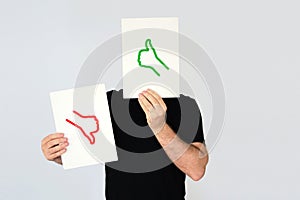 Man holding the thumbs up and thumbs down icons. Social media and costumer feedback concept. photo