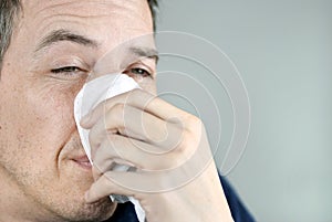 Man Holding Tissue On Nose