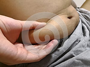 Man holding and touch he skin for check excessive belly fat