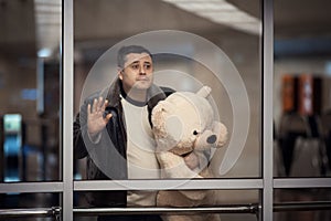 Man holding toy bear and looking sadly into the distance. photo