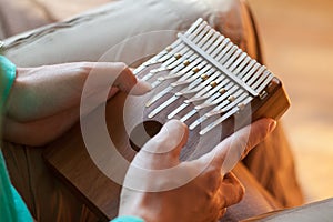 Man holding traditional African musical instrument large kalimba in one`s hands. Man playing on the kalimba.