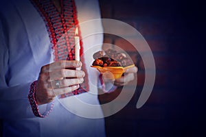 Man holding traditional ramadan food at night