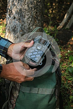 Man Holding Trail Camera Cam in Woods