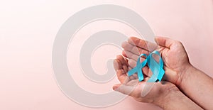 Man holding two Blue Ribbons for supporting people living and illness with prostate cancer and achalasia and photo