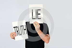 Man holding two cards with the words Lie and Truth photo