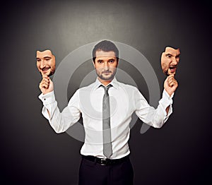 Man holding two masks with different mood