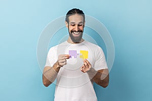 Man holding two puzzle parts and smiling joyfully, ready to connect jigsaw pieces, symbol of union.