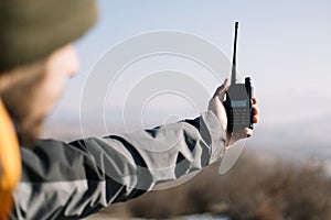 Man holding two-way radio for hiking in the air