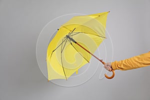 Man holding umbrella caught in gust of wind on grey background, closeup