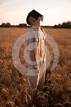 man holding up Bible in a wheat field