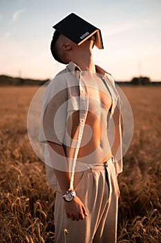 man holding up Bible in a wheat field